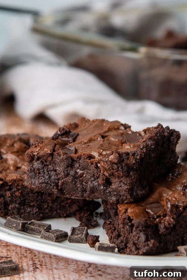 Ultra-Fudgy Almond Flour Chocolate Brownies 2 a stack of three brownies on a white plate