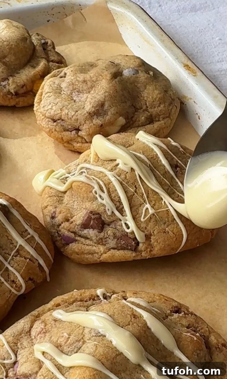 drizzling white chocolate on mini egg cookies.