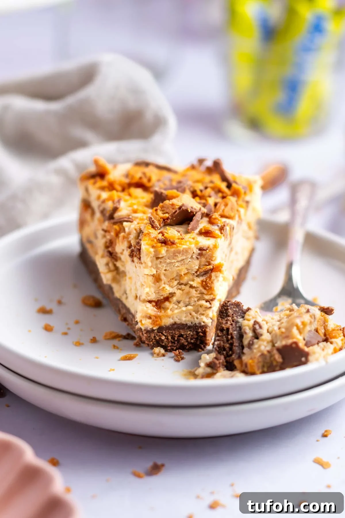 slice of butterfinger pie on a plate with a bite on a fork