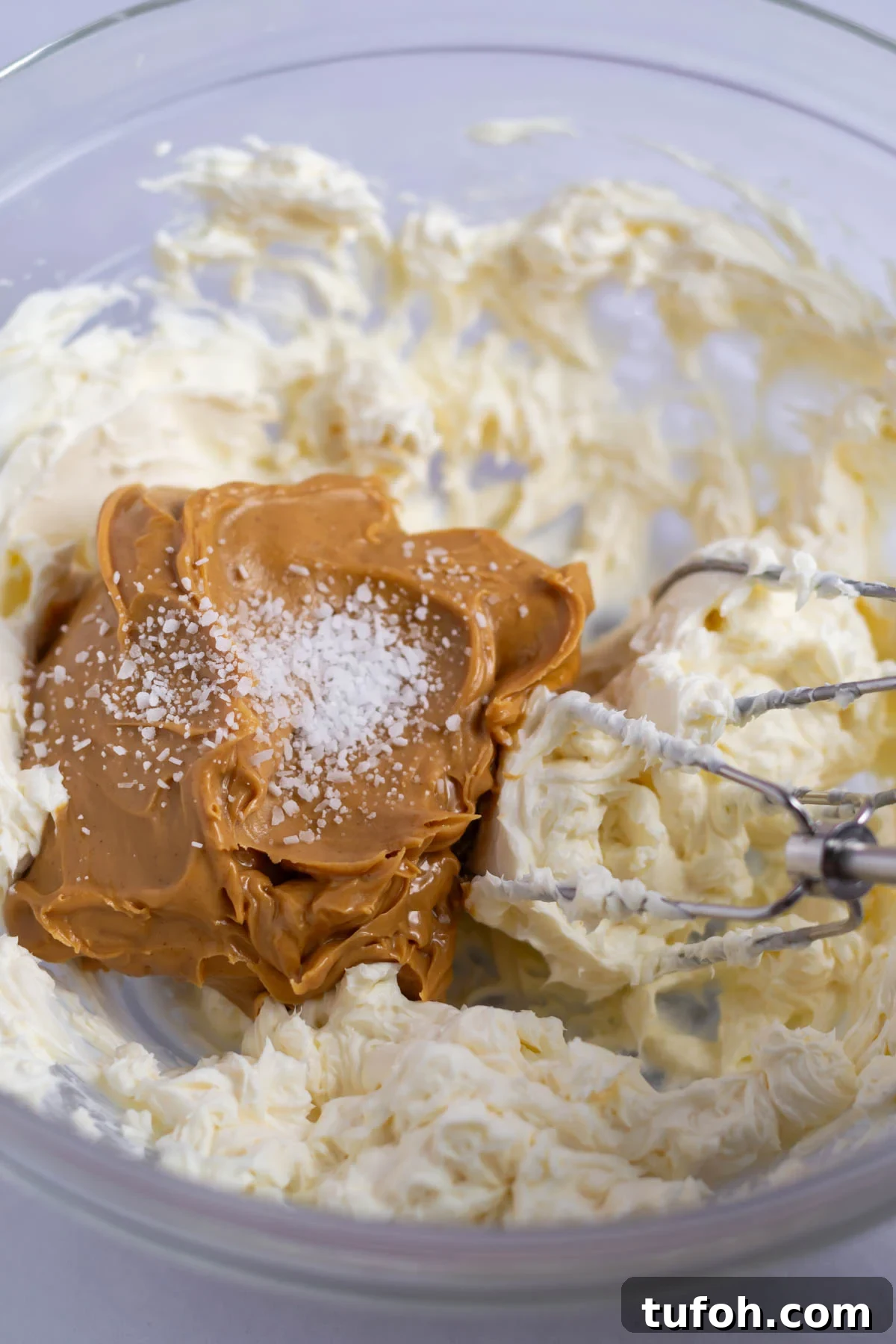 peanut butter and salt added to creamed cream cheese in a bowl