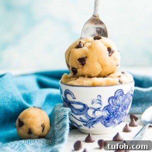 A bowl of edible gluten free chocolate chip cookie dough with a spoon in it.