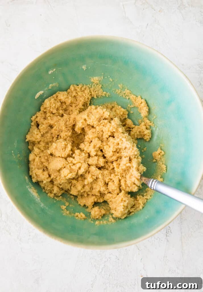 A bowl filled with raw cookie dough with a spoon in it.