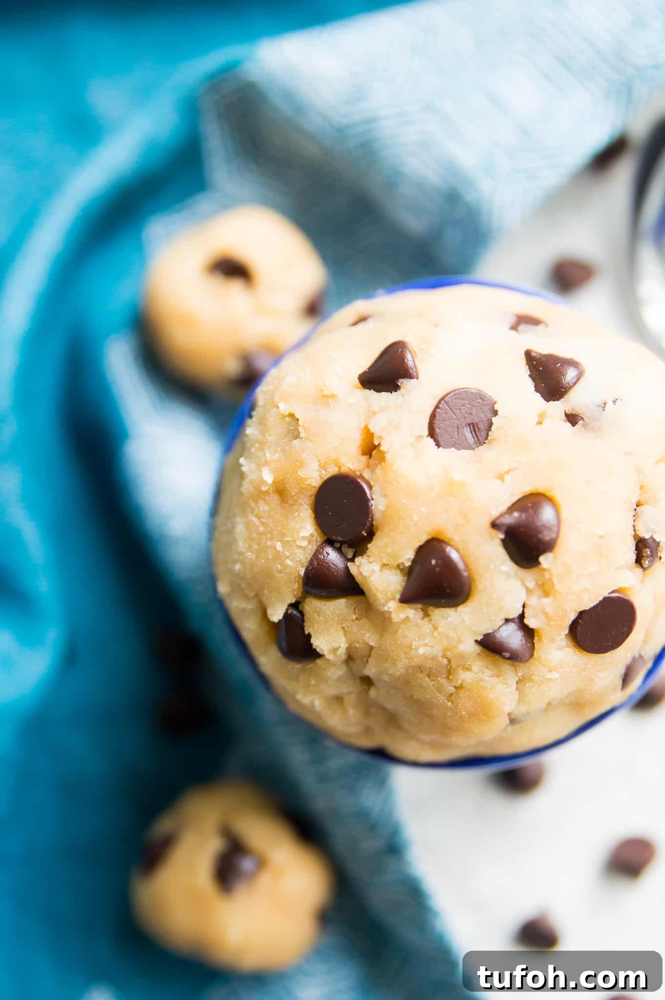 A large bowl of cookie dough with chocolate chips in it.