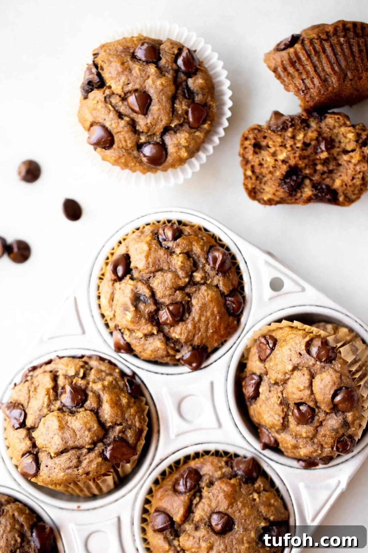 Banana Lentil Muffins: Protein-Packed Breakfast Muffin Recipe 2 overhead photo of freshly baked healthy muffins, chocolate chip banana muffins, in an aluminum muffin pan with milk and chocolate chips in the background