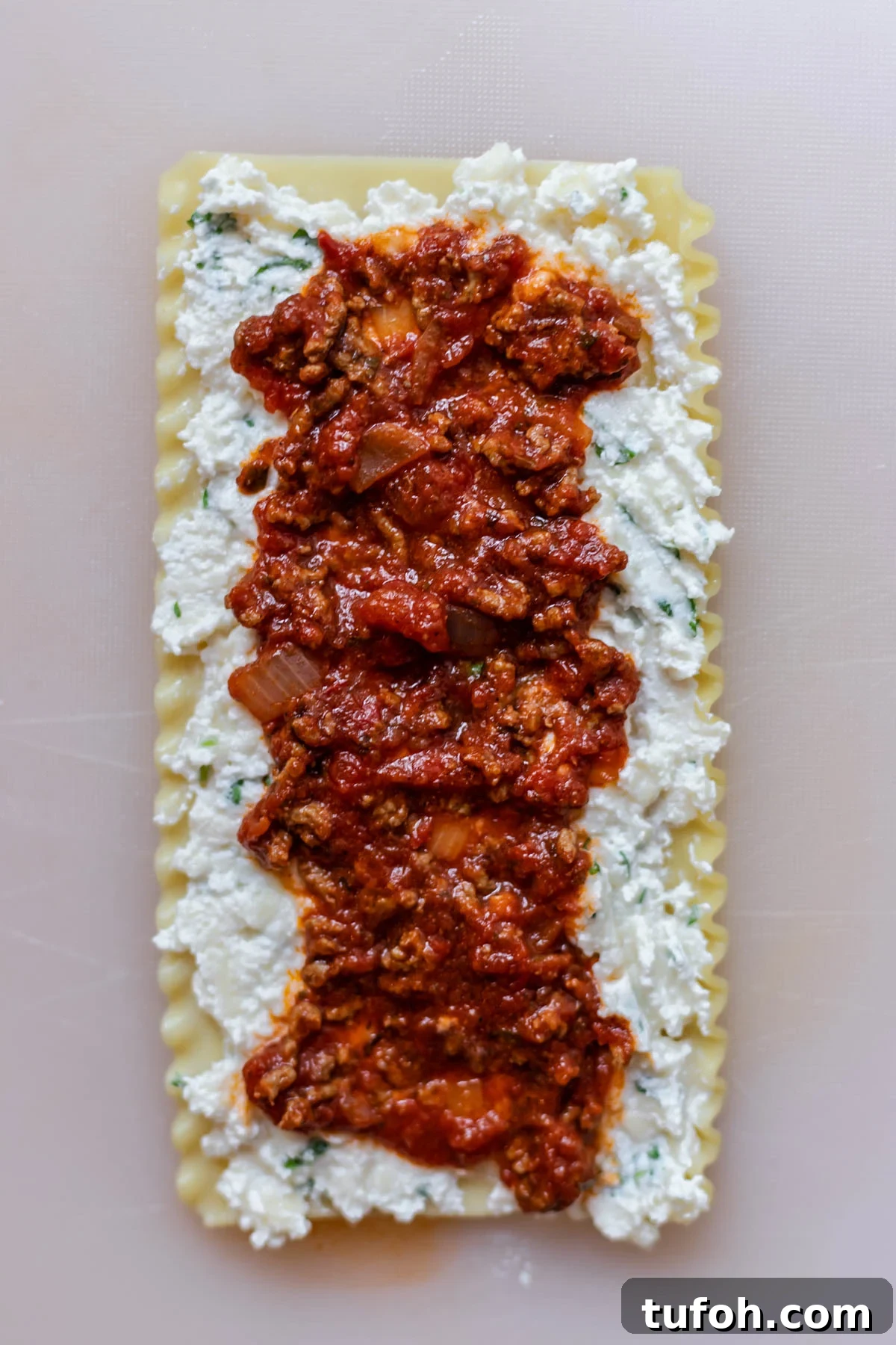 Cheesy Baked Lasagna Rolls with Marinara and Ricotta 5 a sheet of lasagna layered with ricotta cheese and marinara sauce