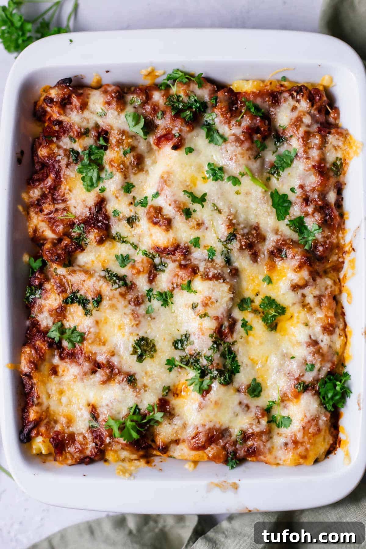 Cheesy Baked Lasagna Rolls with Marinara and Ricotta 8 overhead image of a baking dish full of baked lasagna rolls