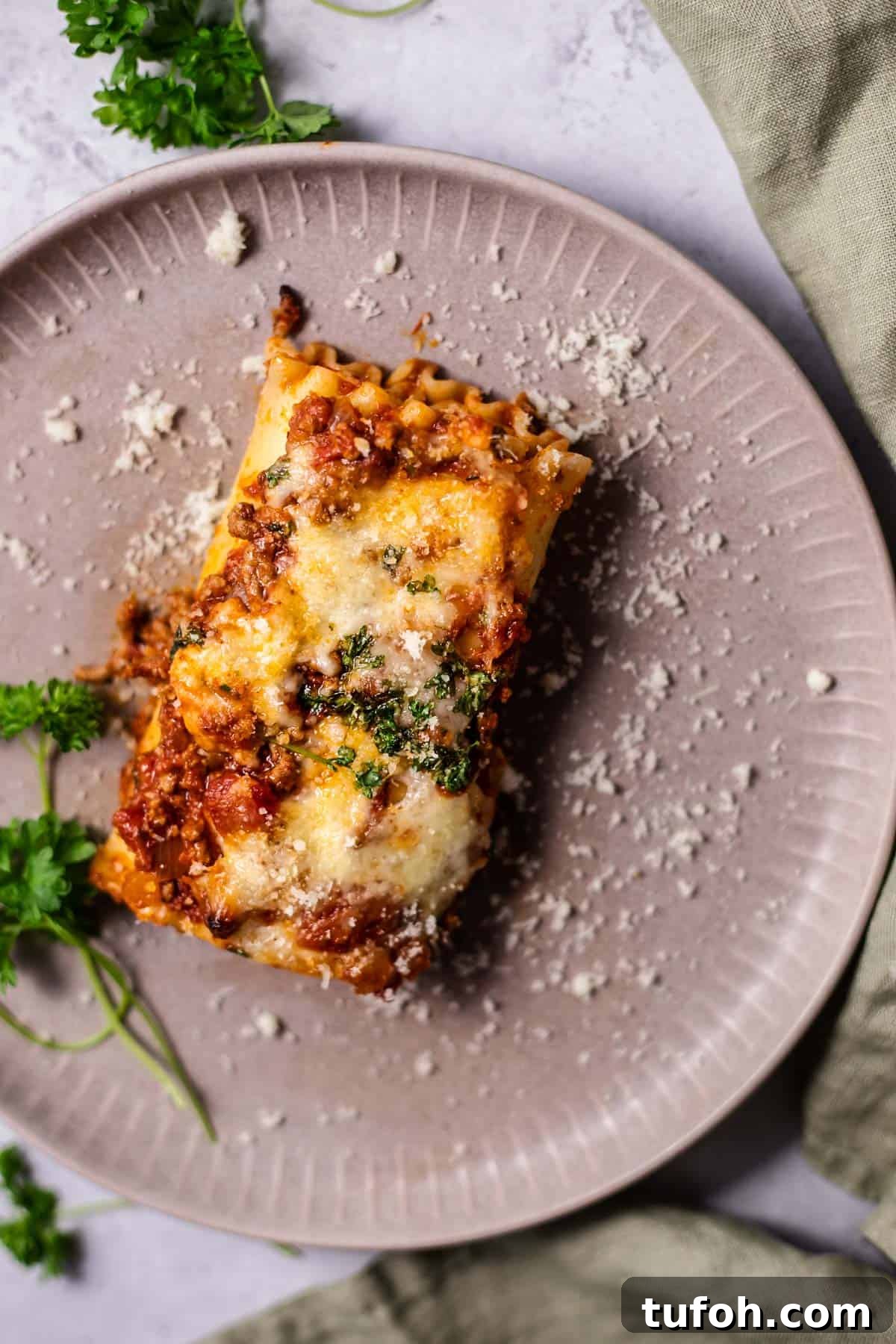 Cheesy Baked Lasagna Rolls with Marinara and Ricotta 9 a baked lasagna roll on a light purple plate