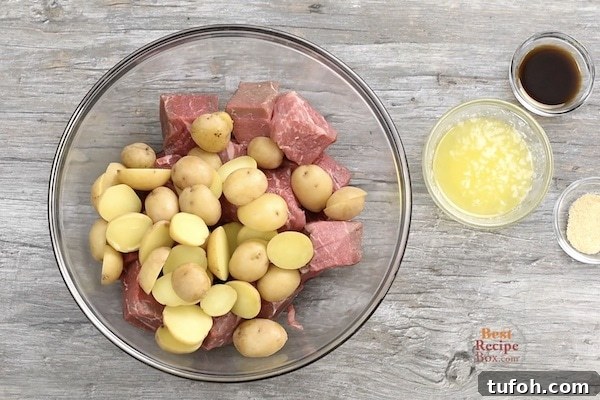 Cut up steak and potatoes in a bowl with flavorings