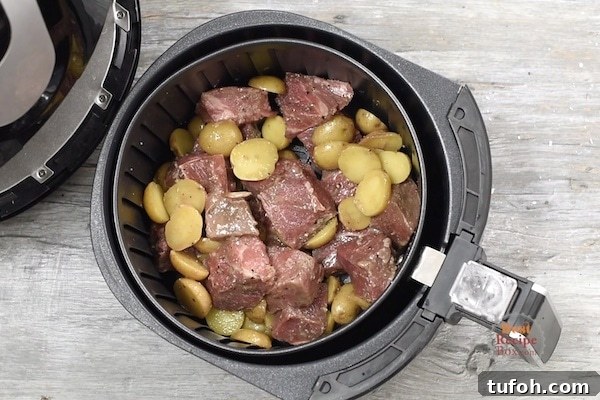 Steak tips and potatoes in air fryer basket