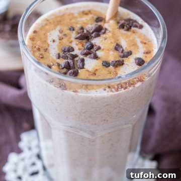 Close up of a Peanut Butter Protein Shake in a glass topped with peanut butter