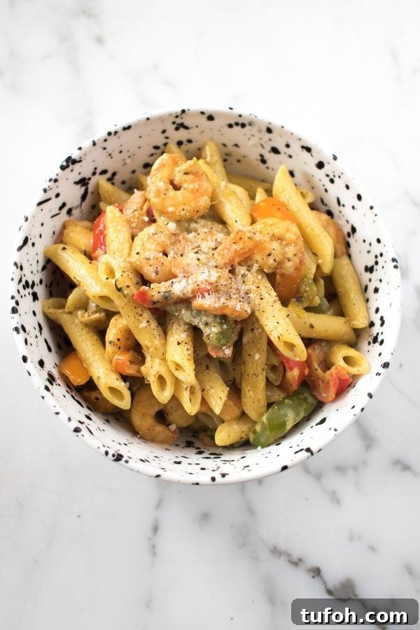 Spicy Jerk Shrimp Rasta Pasta Recipe | Caribbean-Inspired Shrimp Pasta 3 A white and black bowl with shrimp pasta in it