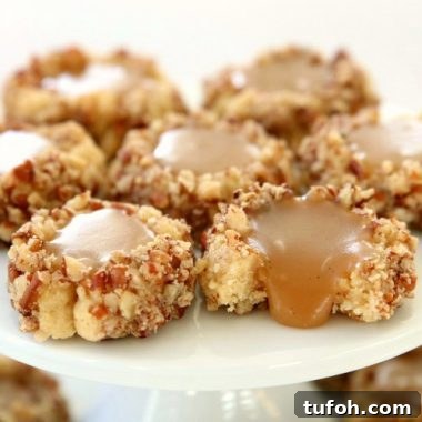 Caramel Thumbprint Cookies are a classic shortbread cookie rolled in pecans, baked & filled with warm caramel. Buttery Christmas cookies that everyone loves seeing at holiday cookie exchanges!