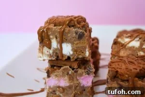 Biscoff Rocky Road Recipe: No-Bake Biscoff Chocolate Squares 2 Slice of Biscoff rocky road with a pink background.