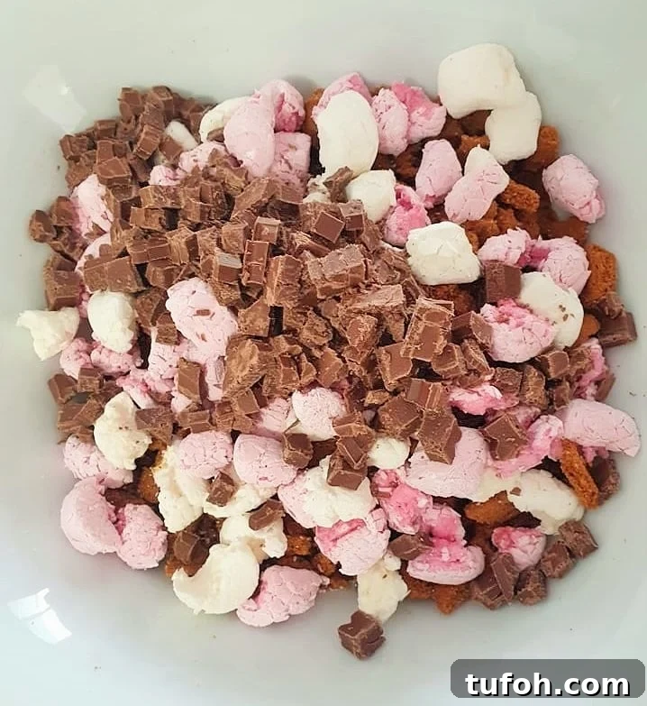 Biscoff Rocky Road Recipe: No-Bake Biscoff Chocolate Squares 9 Chopped chocolate and marshmallows in a white bowl.