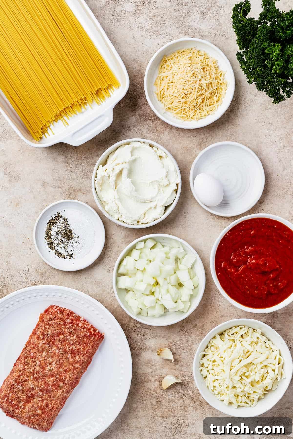 Ultimate Cheesy Baked Spaghetti Casserole Recipe 4 From top left: dry spaghetti, onion, seasonings, ricotta, an egg, mozzarella, marinara sauce, italian sausage, garlic, parmesan.