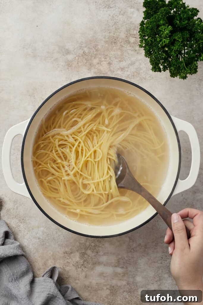 Ultimate Cheesy Baked Spaghetti Casserole Recipe 5 Pasta boiling in a Dutch oven.