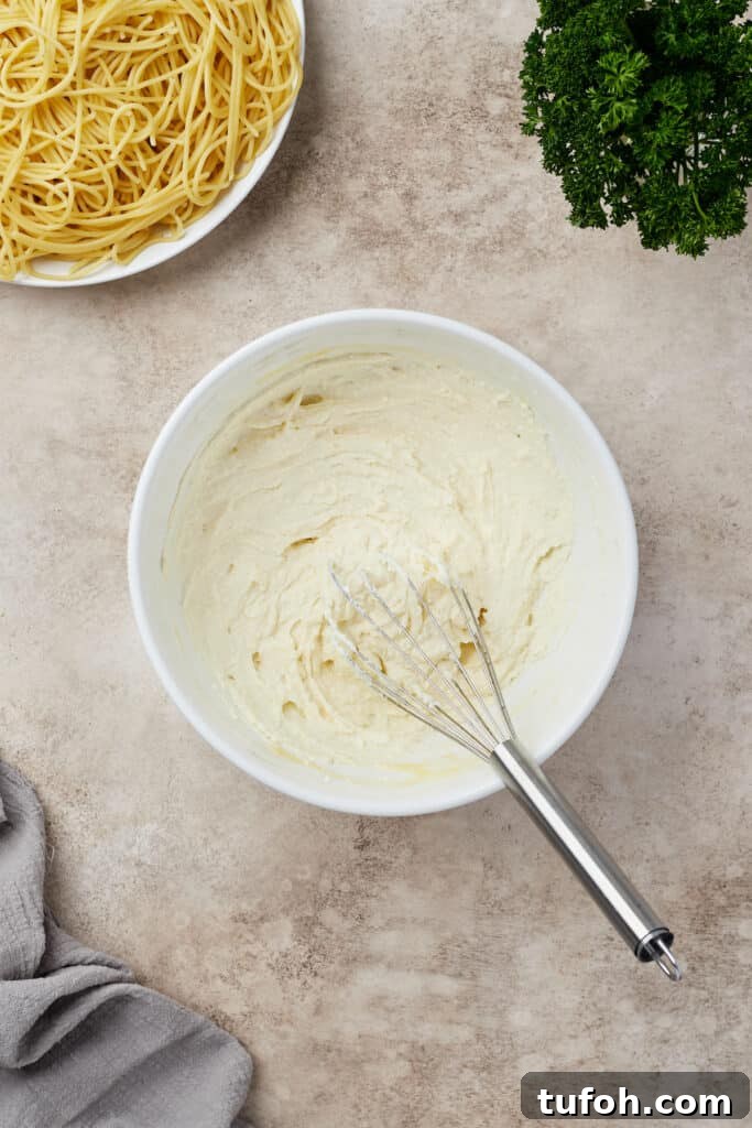 Ultimate Cheesy Baked Spaghetti Casserole Recipe 8 Ricotta and egg whisked together in a mixing bowl.