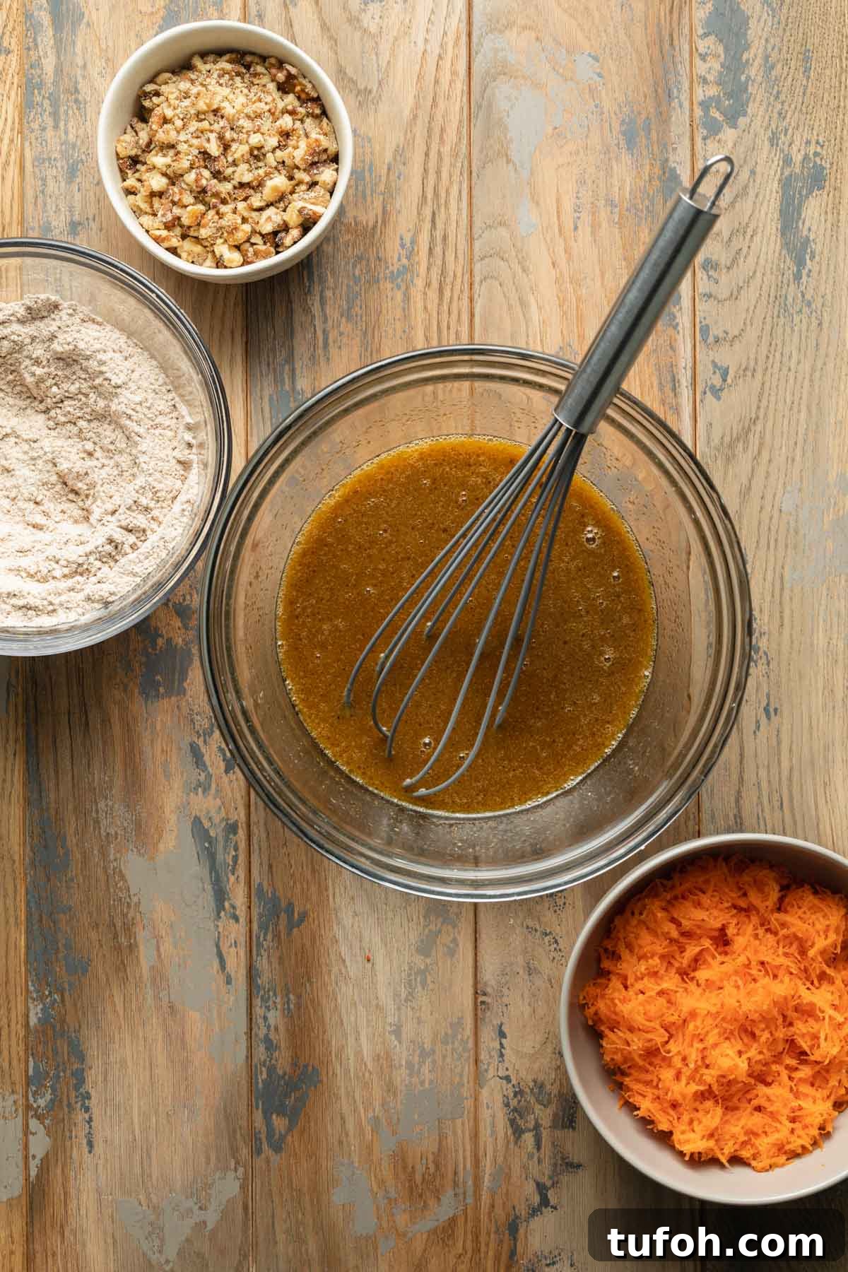 Wet ingredients whisked together in a glass bowl.