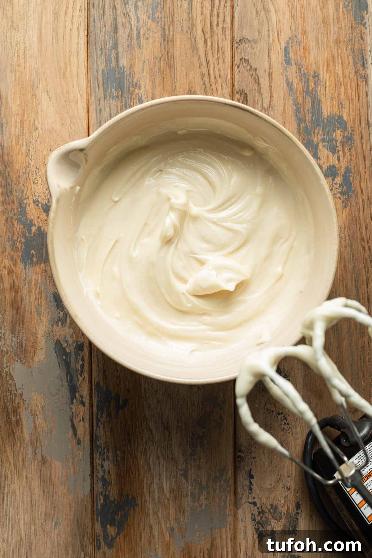 Overhead view of cream cheese frosting in a bowl.
