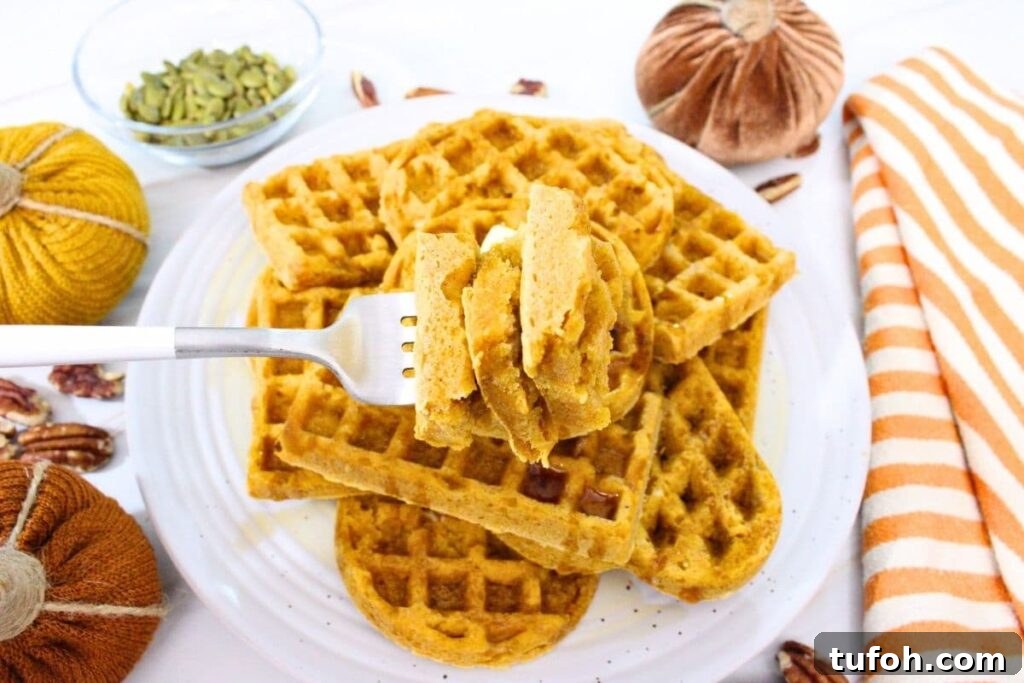 3-Ingredient Air Fryer Pumpkin Waffles for Fall Breakfast 3 holding up a forkful of air fryer pumpkin pancakes