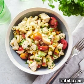 Table setting with a bowl of Pasta Salad with Chicken and a cloth napkin.
