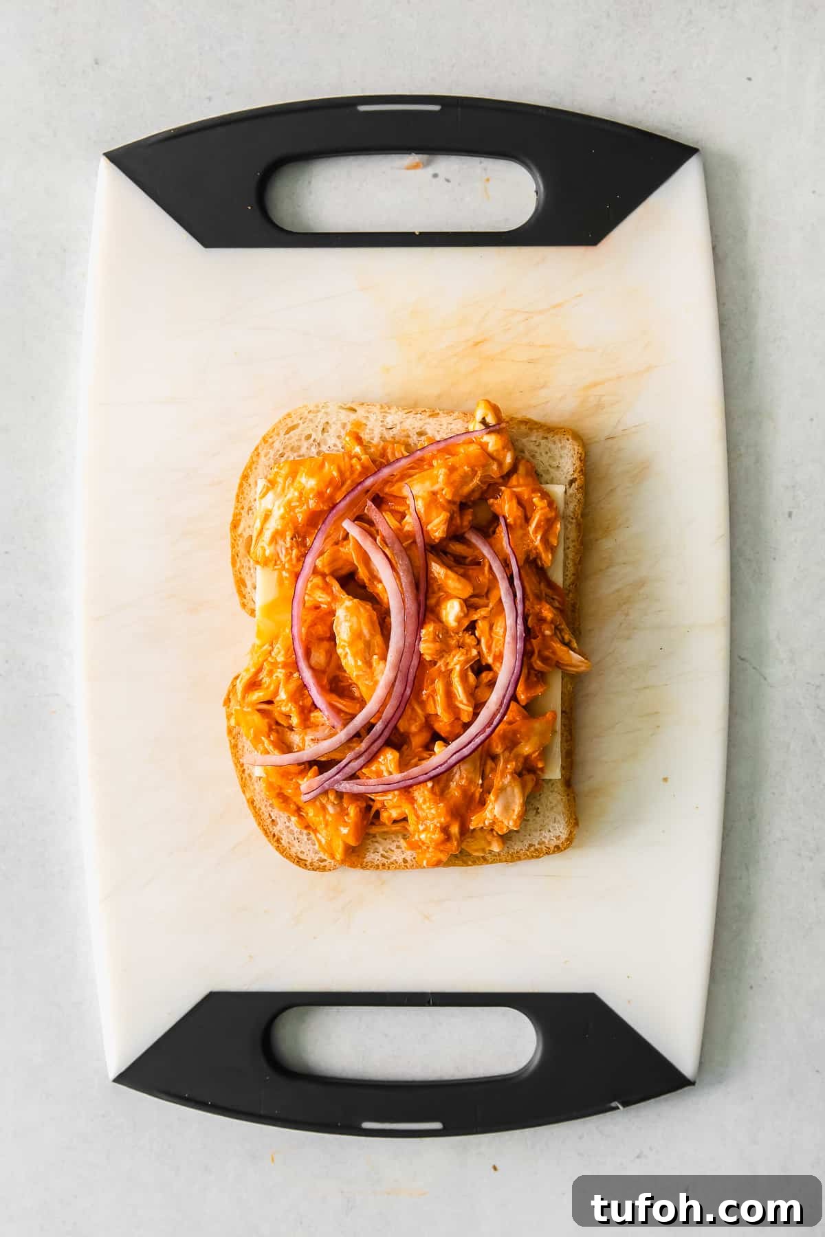 open face grilled cheese on cutting board.