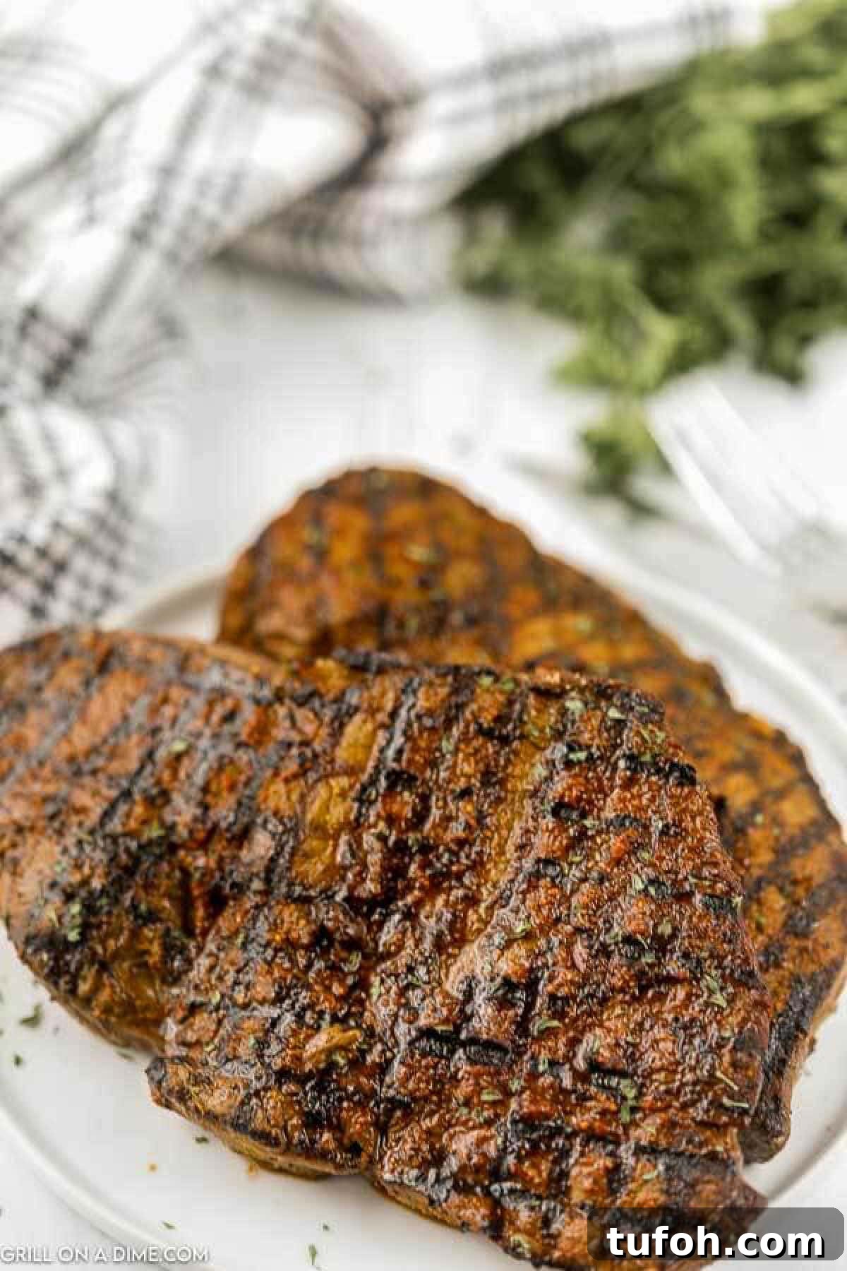 Grilled Sirloin Steaks stacked on a plate.