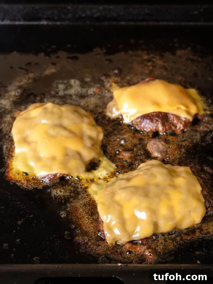Caramelized Onion Smash Burger — Next-Level Flavor 14 American cheese slices added to burger patties on grill