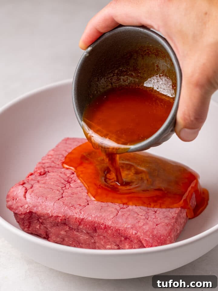 Caramelized Onion Smash Burger — Next-Level Flavor 4 hand pouring paprika butter mixture over ground beef
