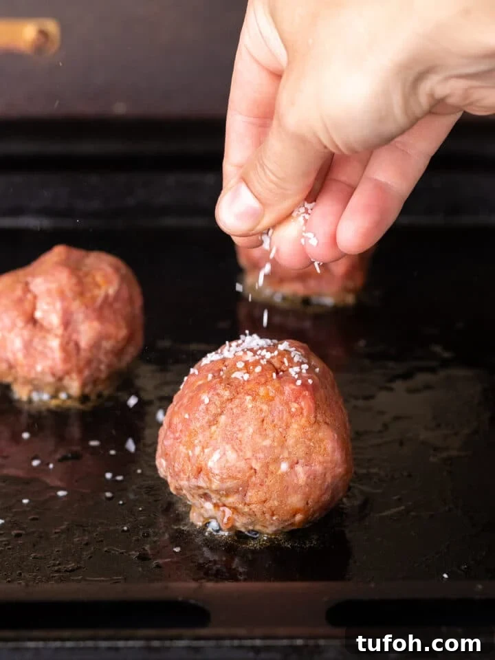 Caramelized Onion Smash Burger — Next-Level Flavor 10 sprinkling salt on a ball of beef on a grill