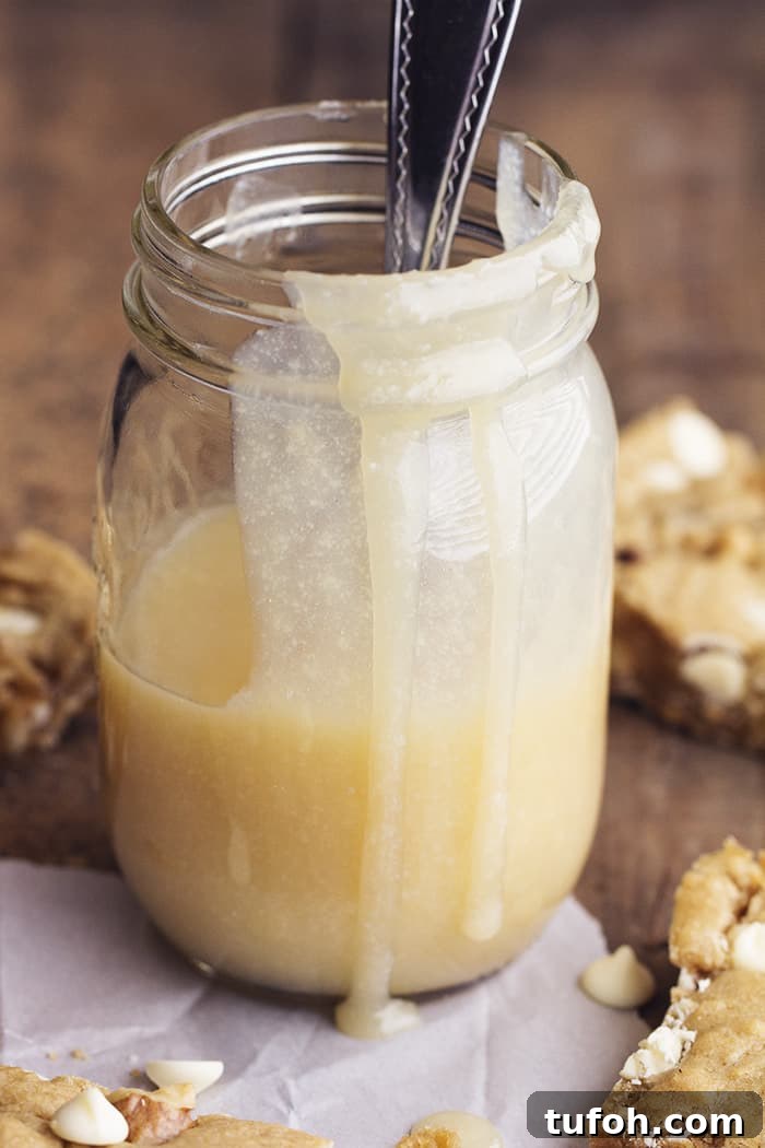 The warm maple cream sauce is rich and creamy—perfect to pour over blondies and ice cream. blondie sauce in a glass mason jar.