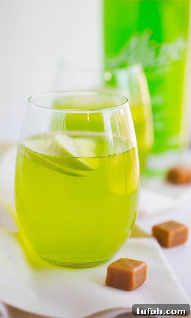 Caramel Apple Cocktail - bright green caramel apple flavored cocktail garnished with apple slices