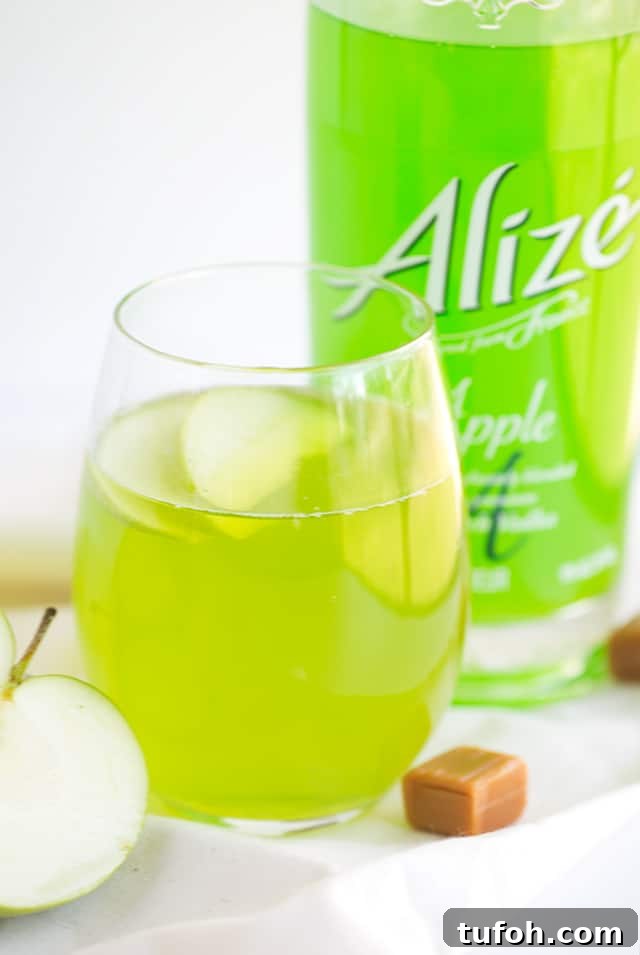 Caramel Apple Cocktail - bright green drink with caramel candies nearby