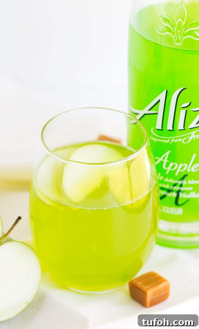 Caramel Apple Cocktail - bright green cocktail garnished with apple slices