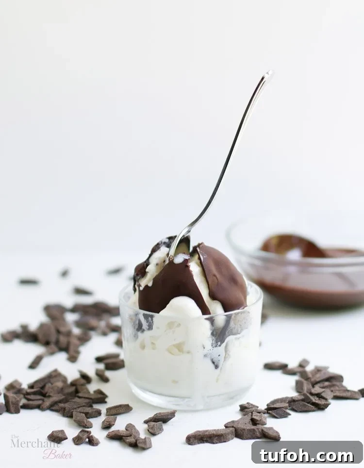 Chocolate Shell Ice Cream Topping: Crunchy Hard Chocolate Coating 8 Chocolate hard shell ice cream topping cracked open with a spoon on a scoop of vanilla ice cream from themerchantbaker.com