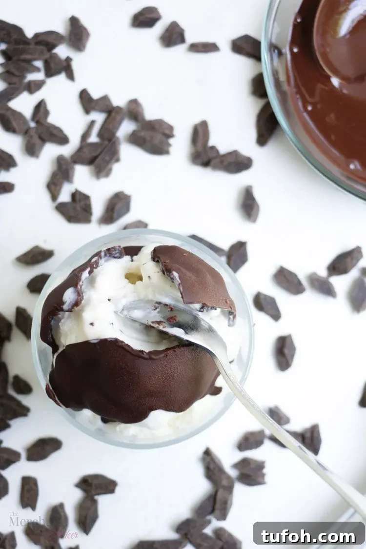 Chocolate Shell Ice Cream Topping: Crunchy Hard Chocolate Coating 10 A top view of Chocolate hard shell ice cream topping cracked open with a spoon on a scoop of vanilla ice cream from themerchantbaker.com