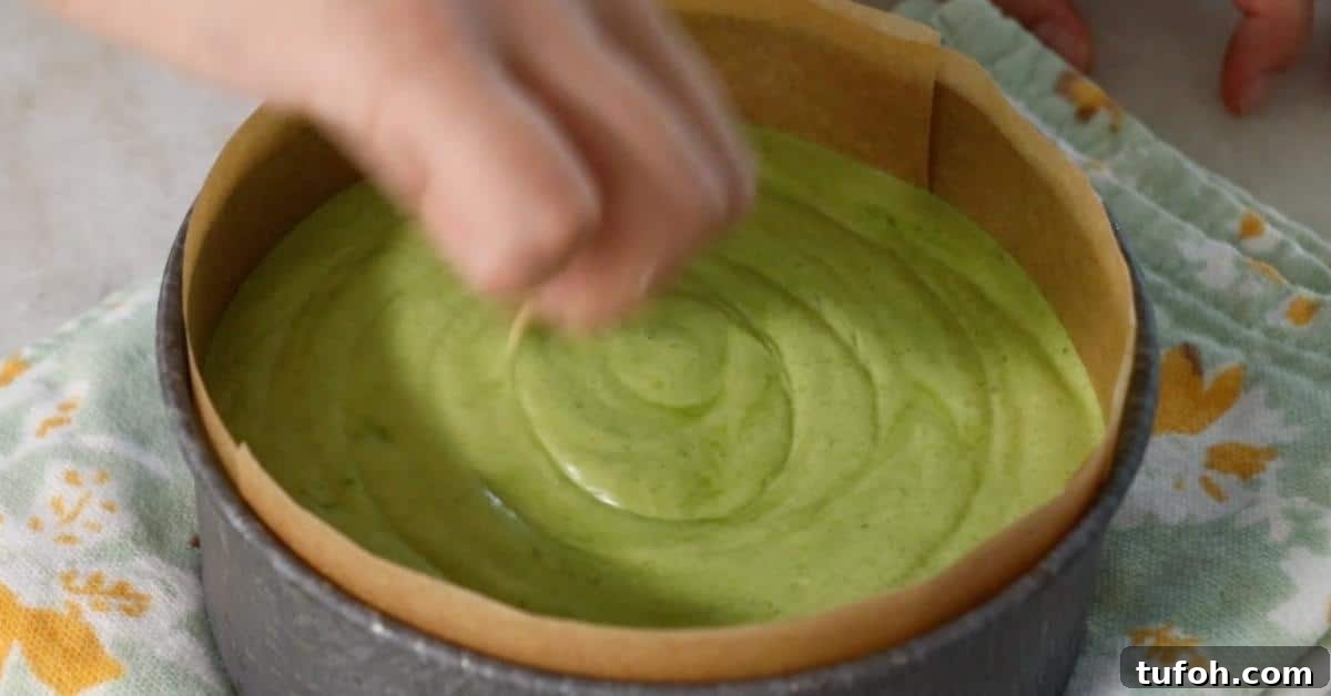 swirling matcha sponge batter in a pan with a toothpick