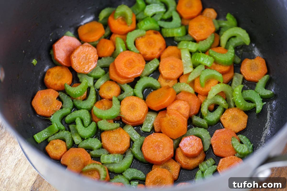 Sautéed celery and carrots in a stock pot.