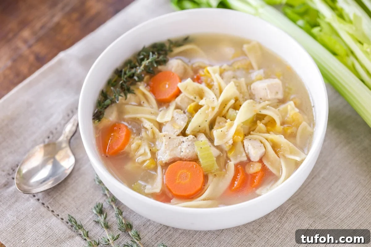 A white bowl of chicken corn soup on the table.