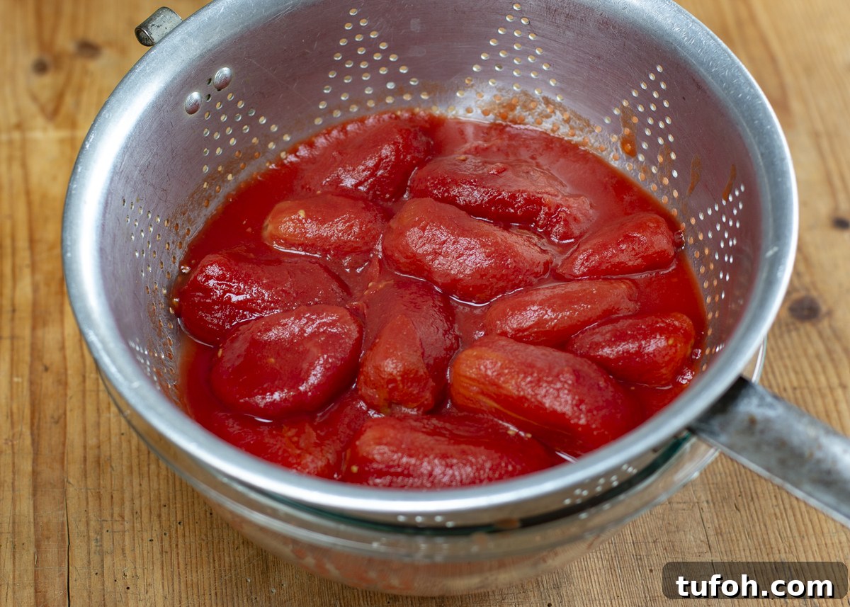 Peeled San Marzano plum tomatoes draining their juices 