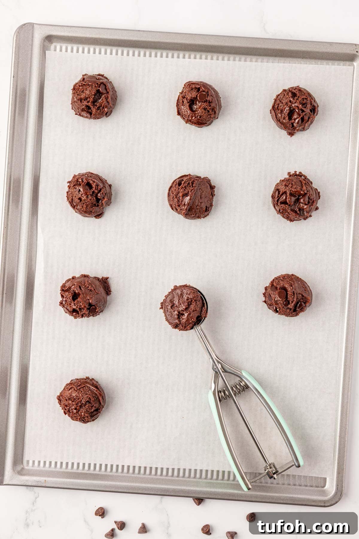 using a mini cookie scoop to place batter onto a baking sheet