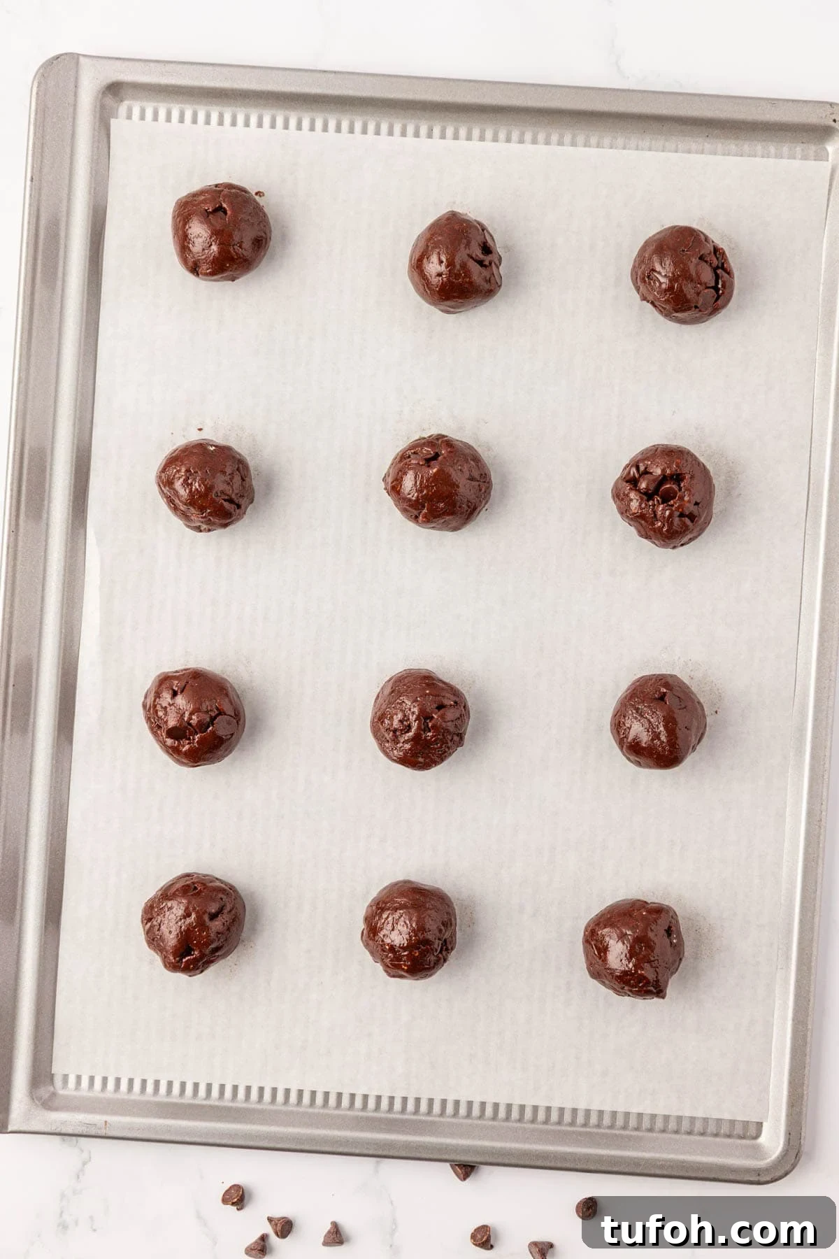 batter rolled into balls on a baking sheet