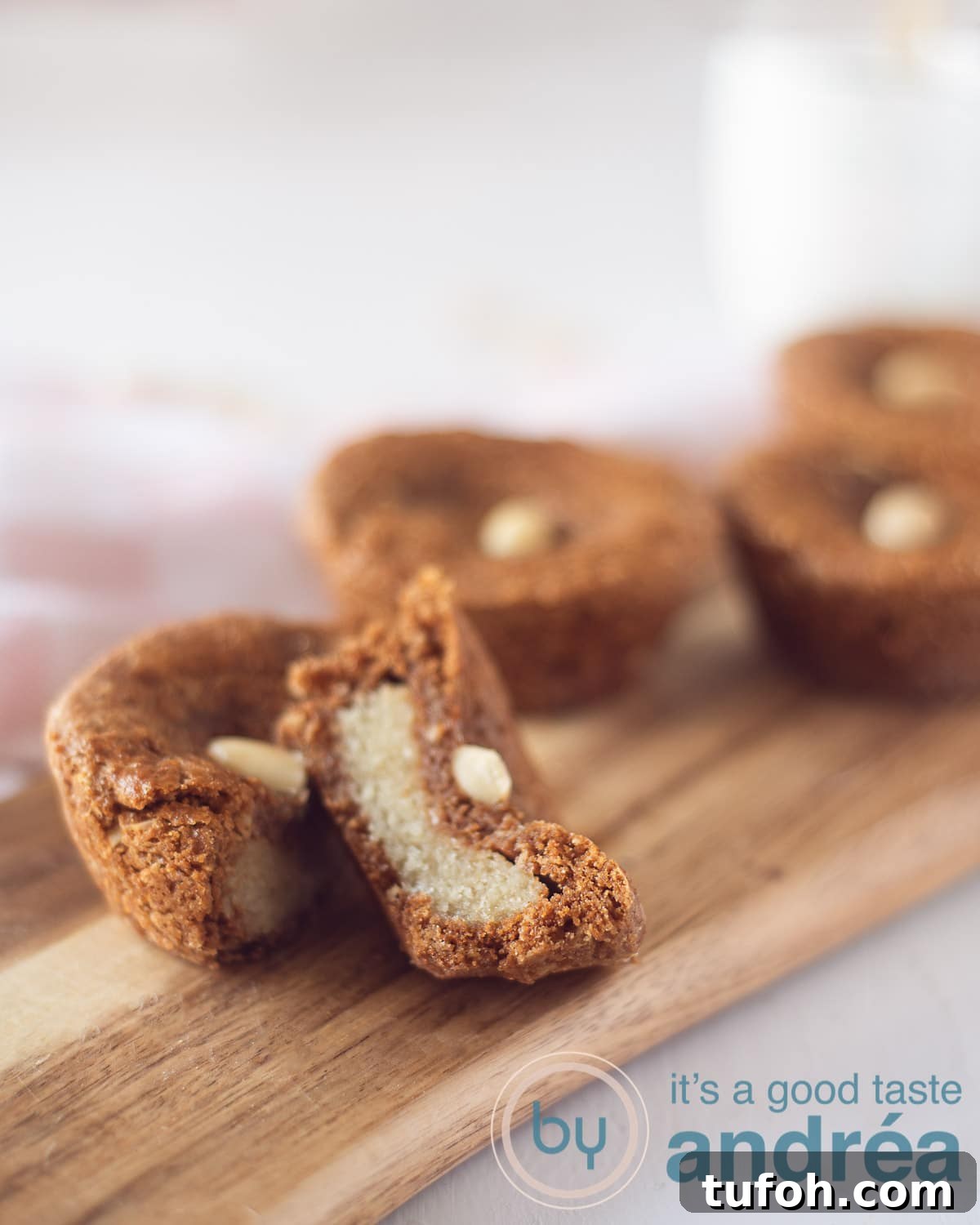 Almond-Filled Speculaas Cookies — Dutch Spiced Shortbread 3 a wooden board with Dutch almond-filled speculaas cookies on a white background. One cookie is sliced in half
