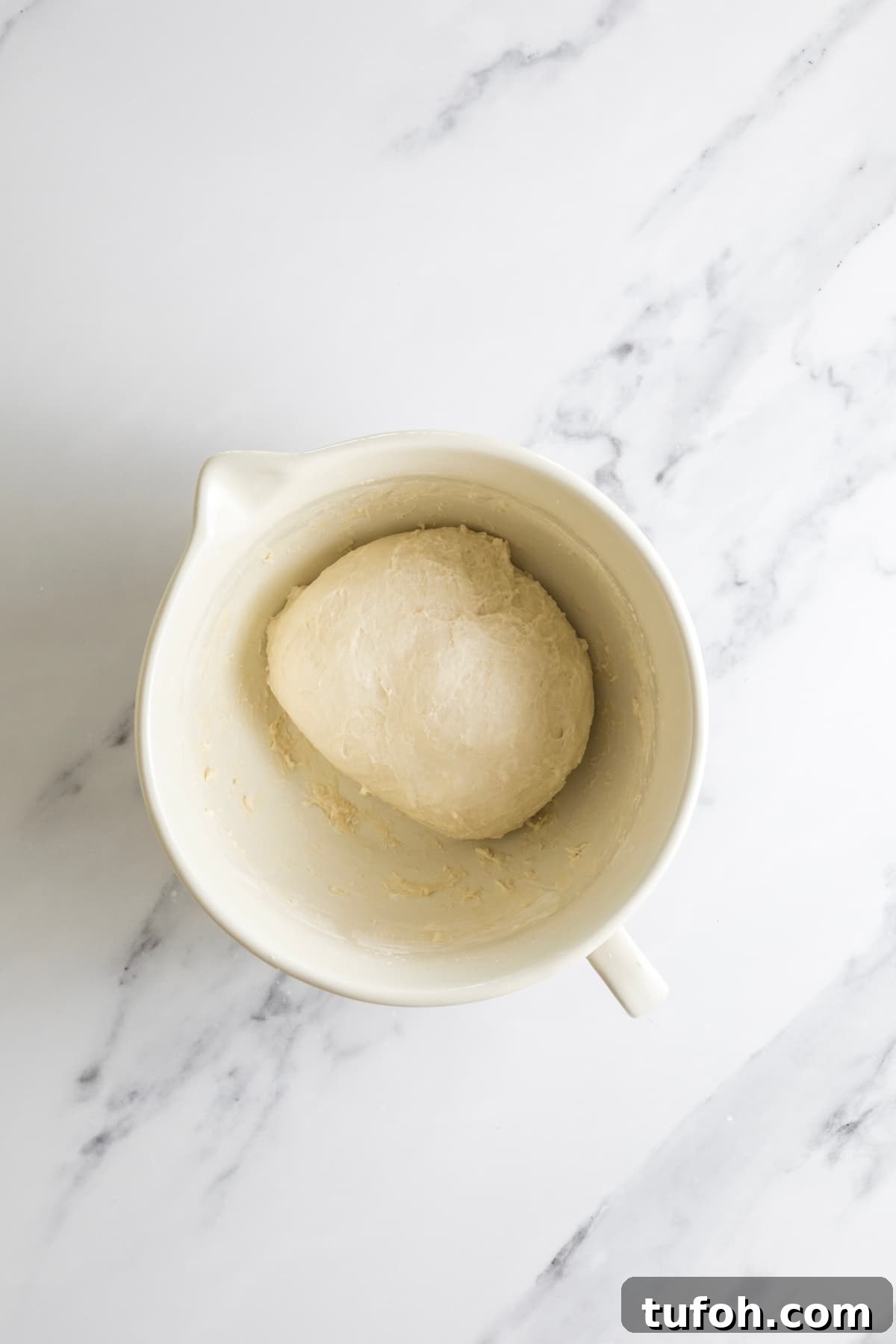Small-Batch Sourdough Loaf Recipe for Home Bakers 5 Smooth small batch sourdough dough ball after kneading in a ceramic bowl.