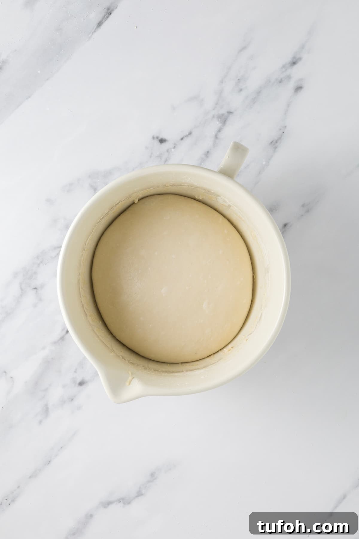 Small-Batch Sourdough Loaf Recipe for Home Bakers 8 Smooth ball of small batch sourdough dough proofing in a ceramic bowl before baking.
