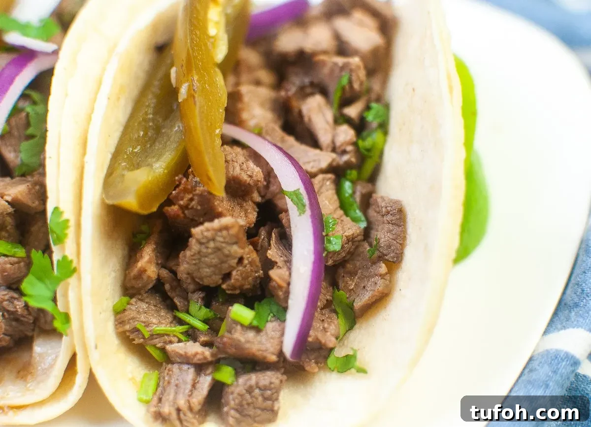 Crispy Air Fryer Street Tacos Recipe for Quick Weeknight Meals 8 Close up looking at tacos- beef, onion, jalapeno and cilantro.