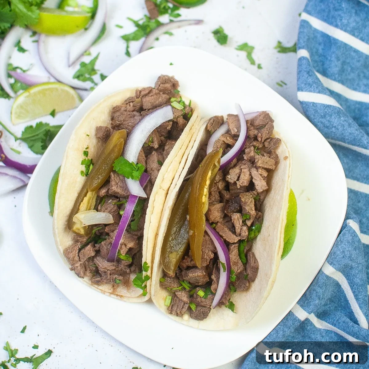 A square white plate with Street Tacos on it.