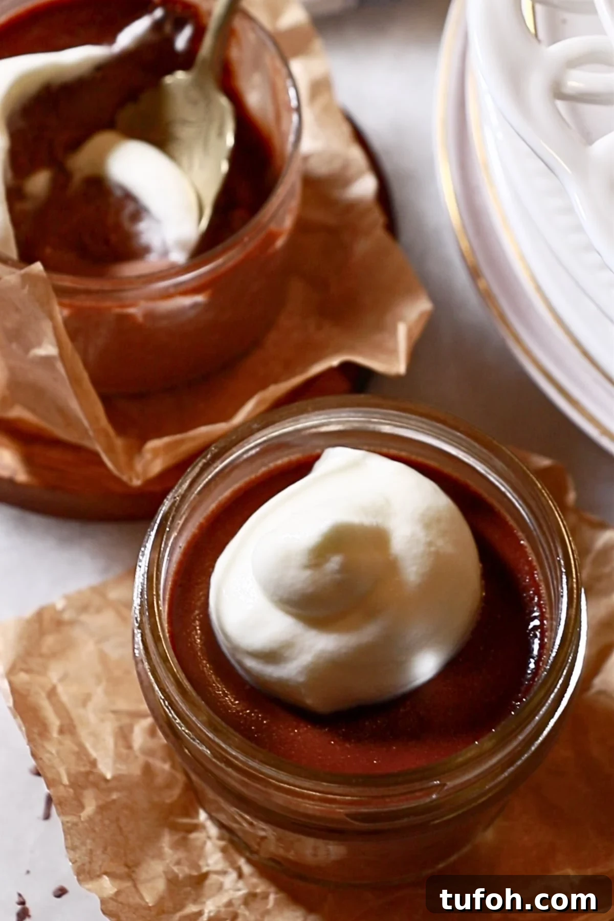 Decadent Baked Chocolate Pudding Recipe for Chocolate Lovers 2 homemade chocolate puddings in glass cups topped with whipped cream