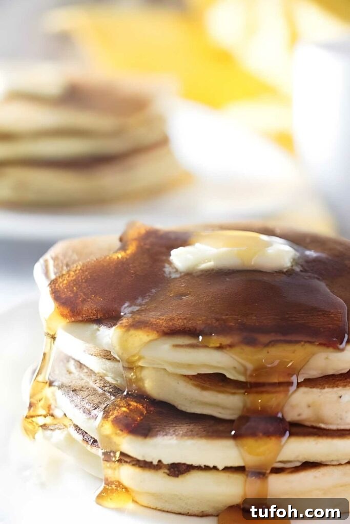 Close-up of lemon ricotta sourdough pancakes with melting butter and syrup.
