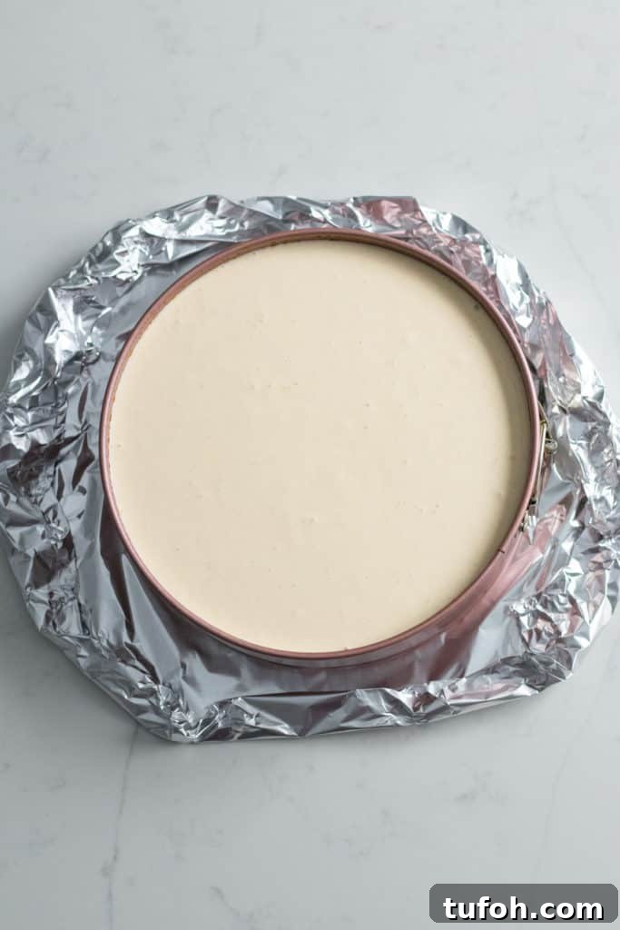 foil wrapped around pan of cheesecake batter
